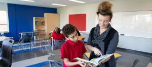 Enseignante d'une école privée dans une classe donnant une explication à un élève